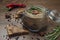 Poultry pate spread on bread and glass jar with poultry pate, decorated with almonds and rosemary, and a few fruits of hot pepper