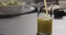 Pour apple celery juice in glass on concrete countertop with copy space