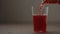 pour berry soft drink in tumbler glass on wood table with copy space