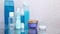 Pour blue shampoo in a small bottle of big through a funnel. Travel set of jars. Bottles of cosmetics close-up.