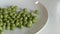 Pour green peas intermittently and the second time they pop out of the plate.