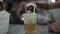 Pour iced tea water into plastic glasses filled with ice on a stainless steel table in the restaurant