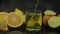 Pour juice into glass, orange and lemon slices on background. Slow motion