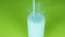 Pour kefir,yogurt into a glass,a beautiful stream of milk,green background.Close-up,fresh dairy product.