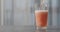 Pour orange fizzy drink into pint glass on concrete countertop with copy space