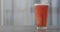 Pour orange fizzy drink into pint glass on concrete countertop with copy space