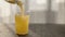 pour orange juice in tonic or water into tumbler glass on oak table with copy space