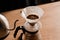 Pour over filter with ground coffee in the funnel in focus. Drip filter coffee brewing. Pour over alternative method of