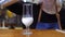 Pour the whipped milk into a glass. A white liquid with bubbles pours into the glass.