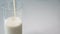 Pour yogurt into a glass. Pour milk, fermented milk product. Close-up