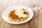 Poured condensed milk, transparent dipper on wafer in saucer on wooden table