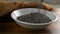 Pouring black chia seeds into a small bowl