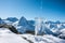 Pouring blue mineral water in transparent glass over winter landscape of mountains higher than clouds