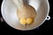 Pouring brown sugar to yolks in metal bowl