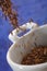 Pouring caraway fruits into a bowl