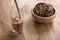 Pouring chocolate milk in glass with homemade chocolate cookies with hazelnuts on background