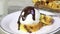 Pouring chocolate sauce over cake and ice cream