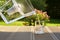 Pouring clear filtered water from a water filtration jug into a glass in green summer garden in a sunny summer day