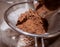 Pouring cocoa powder into a sieve.