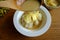 Pouring coconut milk on the sticky rice topping with durian on the wooden table