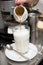 Pouring coffee in milk - preparing latte