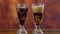Pouring cola soft drink on ice in tall cafe glasses, time lapse.