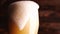 Pouring cold beer into glass, light craft beer forming foam close up