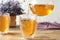 Pouring delicious lavender tea into glass on table