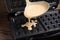 Pouring dough onto Belgian waffle maker