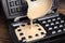 Pouring dough onto Belgian waffle maker, closeup