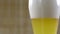 Pouring a foamy drink into a beer glass with light unfiltered beer.
