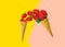Pouring fresh ripe strawberries from waffle cones on duotone yellow pink background. Organic vegan sweets healthy diet
