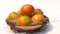 Pouring fresh water on a pile of oranges in wooden bowl on white background