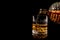 Pouring glass of whiskey on black background