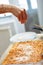 Pouring grated parmesan on lasagna recipe