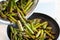 Pouring green asparagus into a pan with warmed sunflower oil