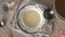 Pouring homemade bone broth into a plate or soup bowl with a ladle, top view