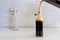 Pouring homemade cold brew coffee from glass jar to glass bottle