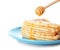 Pouring honey onto tasty thin folded pancakes