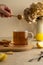 Pouring honey in tea. Glass cup of black tea with lemon, warm neutral background