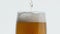 Pouring hoppy liquid glass closeup. Unfiltered barley beer stream filling goblet