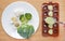 Pouring mashed baby food into container on wooden board for freezing