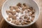 Pouring milk into chcolate cereal pillow in white bowl on table