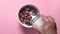 pouring milk on chocolate corn flakes in a bowl on pink background