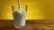 Pouring milk from jug to glass on a rustic wooden table