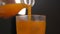 Pouring orange juice into a glass with ice. Filling glass with orange juice in slow motion