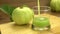 Pouring organic fresh guava juice into transparent glass.