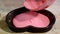 Pouring pink mousse into heart shaped molds. Confectioner making mousse cake in the kitchen