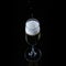 Pouring process of sparkling wine into champagne glass, splashes, drops and froth around glass