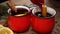 Pouring of red cup with mulled wine on festive table